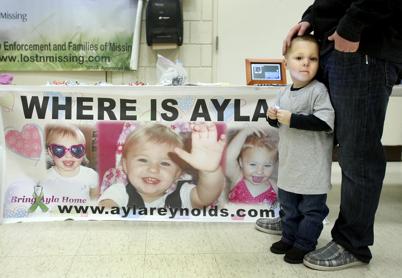 Dayton Kidd, 2, of Windham attends the Shining Hope for Ayla event at the Riverton Community Center in Portland with Chris Lewis on Saturday. It was the latest of several events in the past year to remind the public that the little girl is still missing.