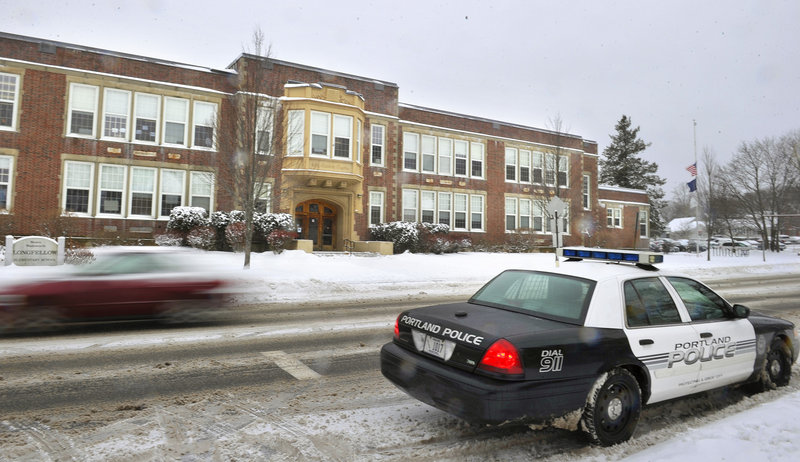 A Portland police cruiser sits Monday in front of Longfellow Elementary School on Stevens Avenue as police stepped up patrols of schools in the wake of the Newtown, Conn., shootings.
