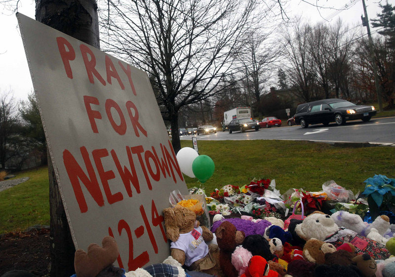 A hearse carrying the casket of of six-year-old Jack Pinto passes a makeshift memorial on its way to Newtown Village Cemetery in Newtown, Connecticut. Legislative leaders are reacting coolly to a bill – proposed after the Connecticut shooting – that would allow concealed-weapons permit holders, including teachers and school administrators, to bring guns to public schools in Maine.