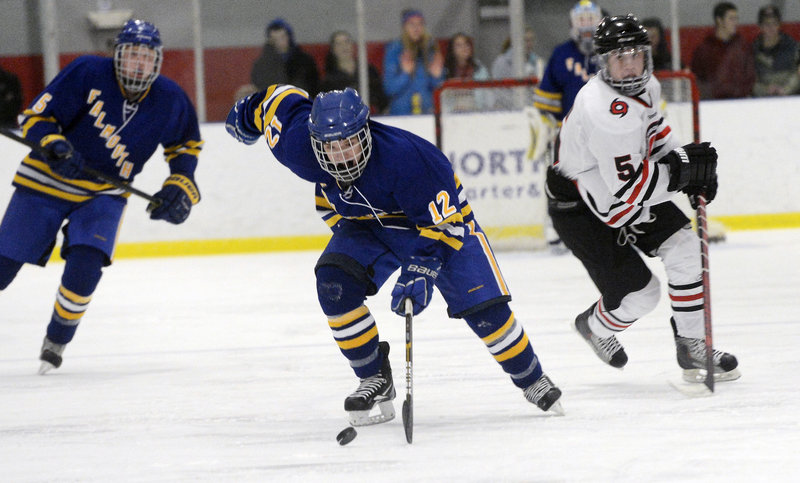 Andre Clement of Falmouth carries the puck up the ice as Scarborough defenseman Nick Bagley trails the play.