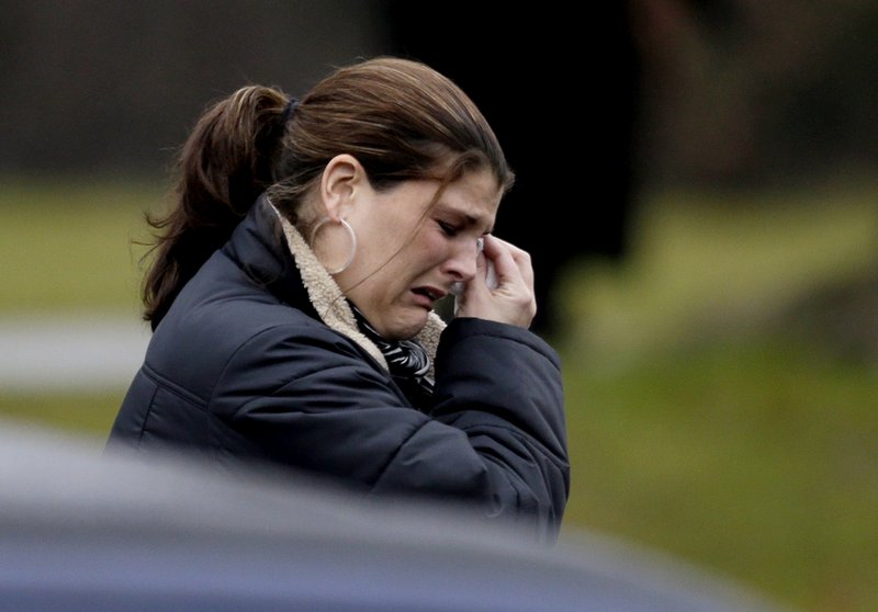 A mourner weeps at the funeral of a young Newtown, Conn., school shooting victim. Readers find fault with society and gun regulations.