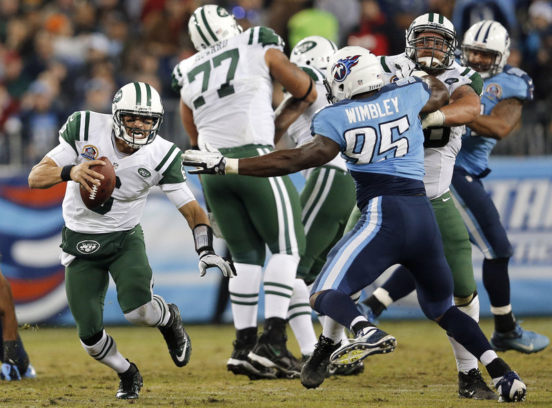 Jets quarterback Mark Sanchez scrambles away from Titans defensive end Kamerion Wimbley during Monday’s game in Nashville, Tenn. Sanchez committed five turnovers, and the Jets were eliminated from playoff contention with a 14-10 loss.