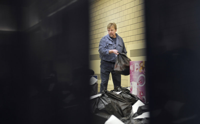Gary Herson, a volunteer with the Salvation Army, picks up a parcel of food and gifts to deliver to a family in need at the Portland Corps of the Salvation Army Tuesday, December 18, 2012.