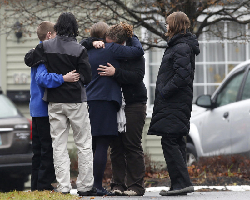 Mourners embrace Monday outside the Newtown, Conn., funeral home where a service was held for one of the 20 local schoolchildren killed Dec. 14. Readers take issue with a column critical of the NRA in the context of the tragedy.