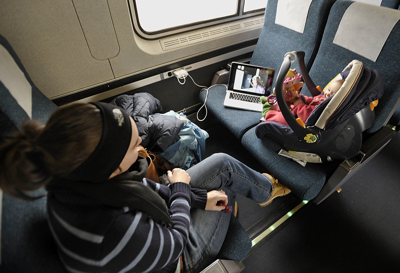 Wendelin Choiniere rides the Amtrak Downeaster on Wednesday with her daughter, Madison, 9 months, right, and son, Mason 2, sleeping on the seat to her left. They live in Brunswick and had made the trip to Exeter, N.H., for a pre-Christmas visit with Choiniere’s mother.