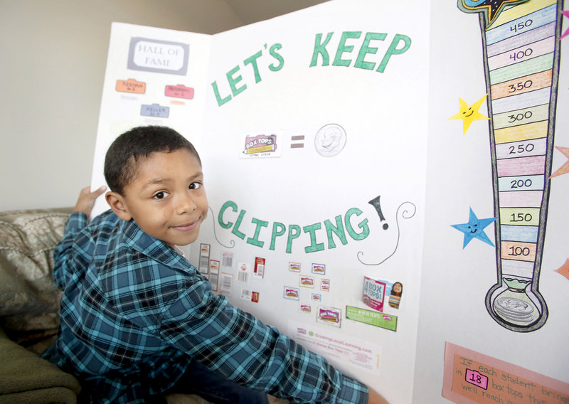 Max Ngabo, 8, of Portland, displays a board he made for his school about collecting Box Tops and UPCs for Labels for Education to raise money for his school.