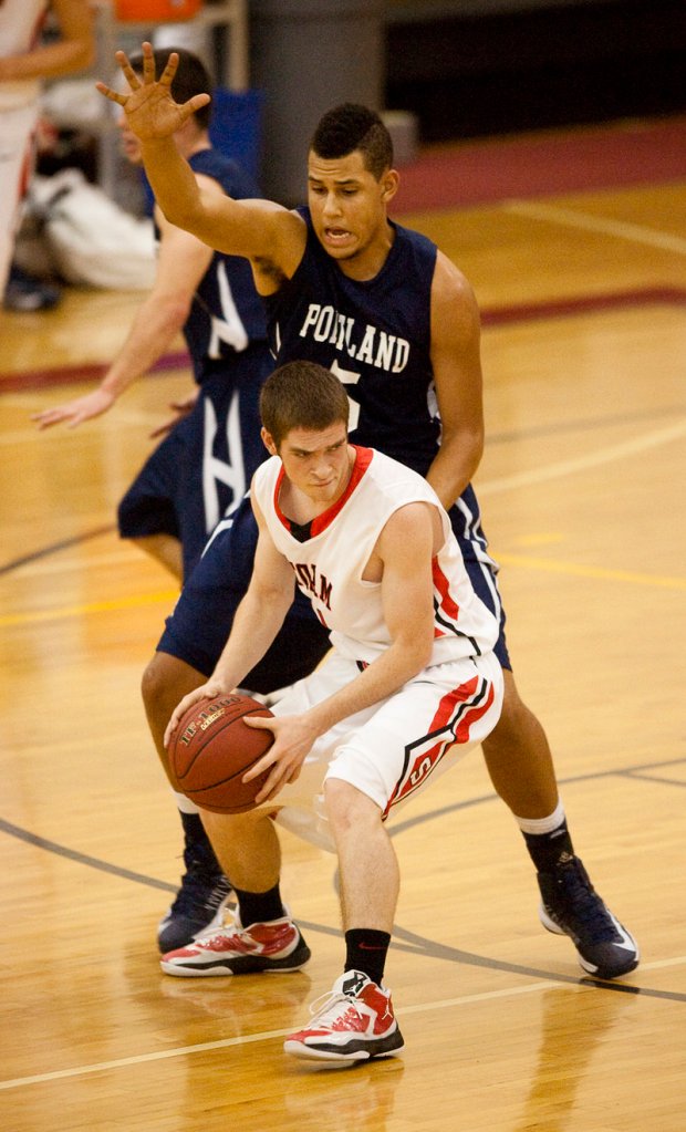 Kevin Manning of Scarborough looks for an open teammate while guarded by Portland center Matt Talbot. Manning led Scarborough with 19 points, while Talbot finished with 14 points for the Bulldogs.