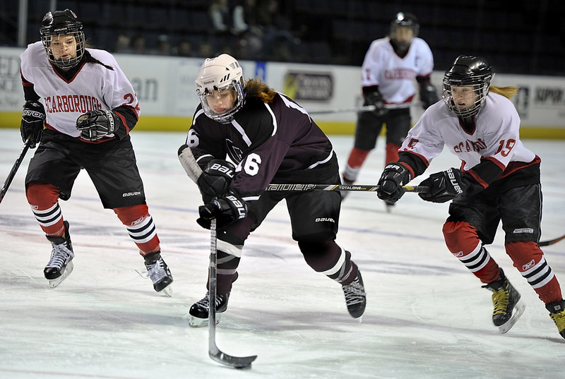 Danita Storey of Greely tries to maintain control of the puck while chased by Scarborough’s Jenna Block, left, and Riley McKeown.