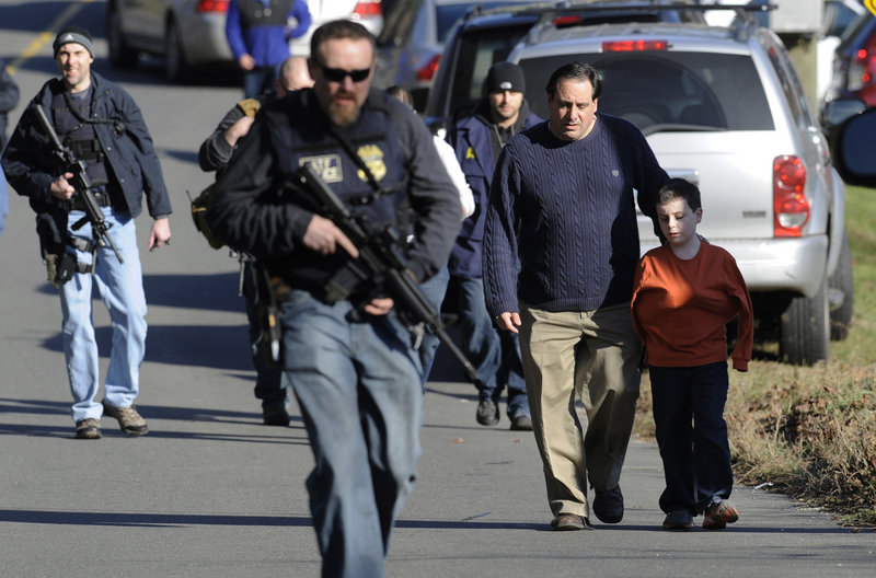 Parents leave a staging area after being reunited with their children Dec. 14 at Sandy Hook Elementary School in Newtown, Conn., where Adam Lanza fatally shot 20 children. Lanza is said to have had Asperger’s disorder, but experts say that would not have predisposed him to violence.