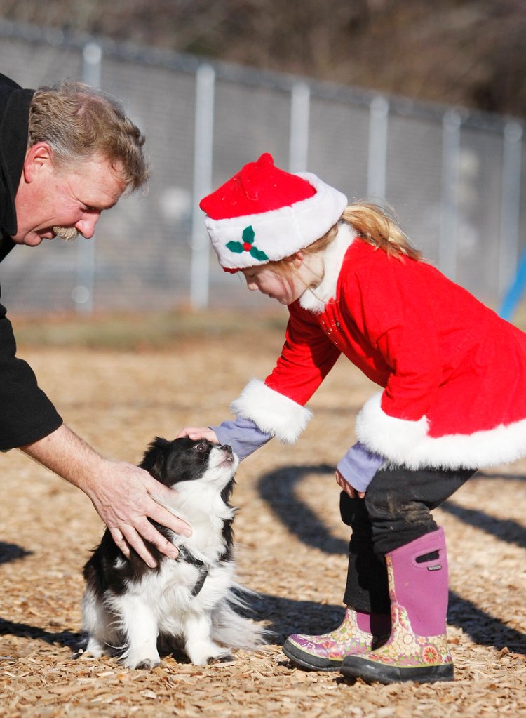 Daisy, a 6-year-old Shih Tzu mix owned by Joe Corriveau of Saco, left, gets a greeting from Parker Roenick, 5, also of Saco, at the Young School playground in Saco on Sunday.