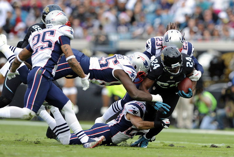 Jacksonville running back Montell Owens, a former University of Maine player, is surrounded by the New England defense as he is tackled during the first half of the Patriots’ win on Sunday. Owens, the leading rusher for the Jaguars on the day, had 10 carries for 42 yards.