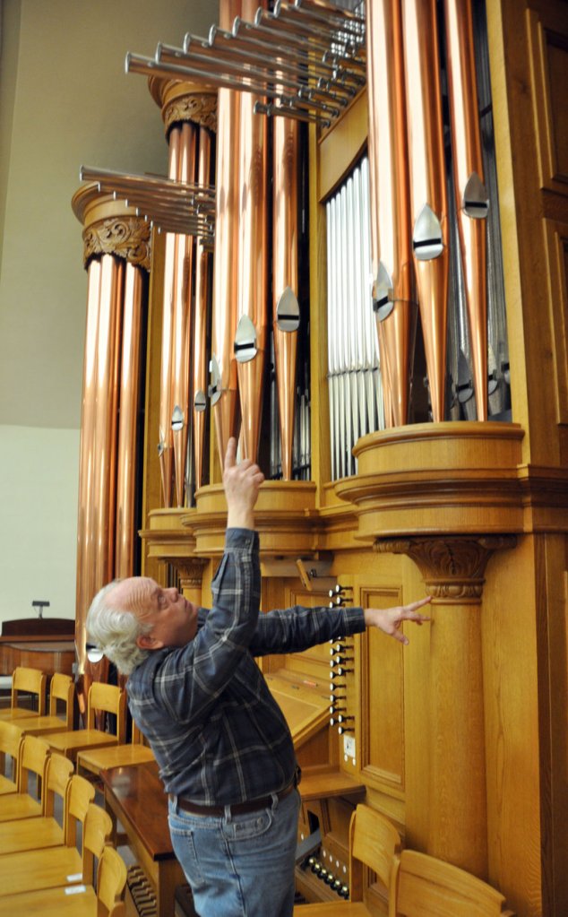 Organ builder John Nordlie points at some of the towering pipes on an instrument he built for First United Methodist Church, in Sioux Falls, S.D.