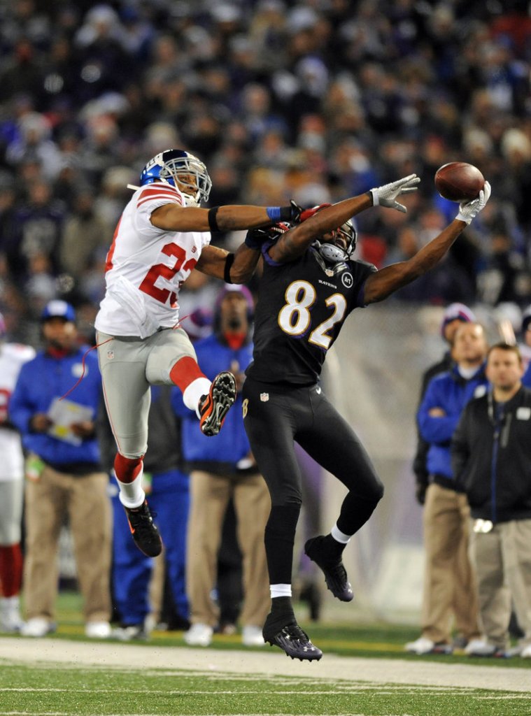 Torrey Smith of the Baltimore Ravens makes a one-handed catch despite the efforts of the New York Giants’ Corey Webster in last Sunday’s game, won by the Ravens.