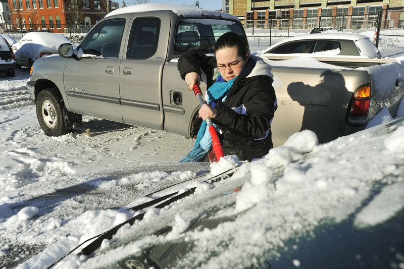 Portland residents retrieve their cars from the city's impound lot after having them towed during the recent snowstorm. Jessica Frenette, who had her car towed from Cumberland Avenue, scrapes ice and snow from her car before leaving the lot on Friday afternoon, Dec. 28, 2012.
