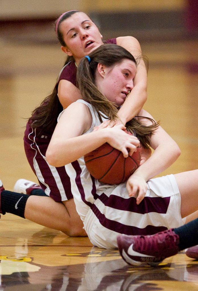 Sadie Nelson of Windham attempts to keep possession of the ball while Emily Richard of Thornton Academy seeks to force a held ball.