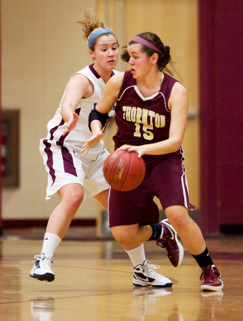 Emily Richard of Thornton Academy controls the ball and heads to the lane while looking for a way to dribble around Katie Herzig of Windham.