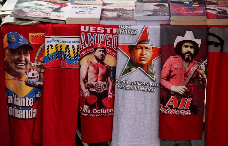 T-shirts with images of Venezuela’s President Hugo Chavez are for sale next to a T-shirt of Venezuelan musician Ali Primera in Caracas, Venezuela, on Friday. Conversations about Chavez’s health have dominated the country since its leader went to Cuba two weeks ago.