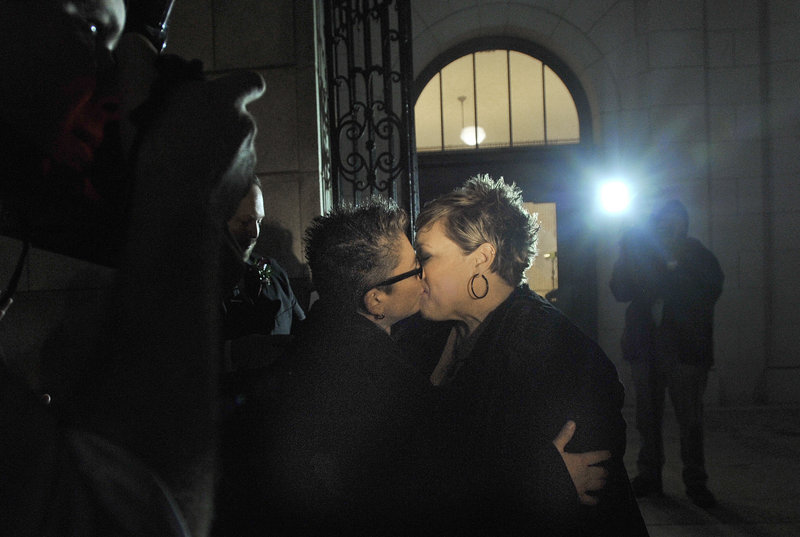 Portland newlyweds Donna Galluzzo, left, and Lisa Gorney share their first kiss as a married couple on the steps of Portland City Hall at 1:45 a.m. Saturday.