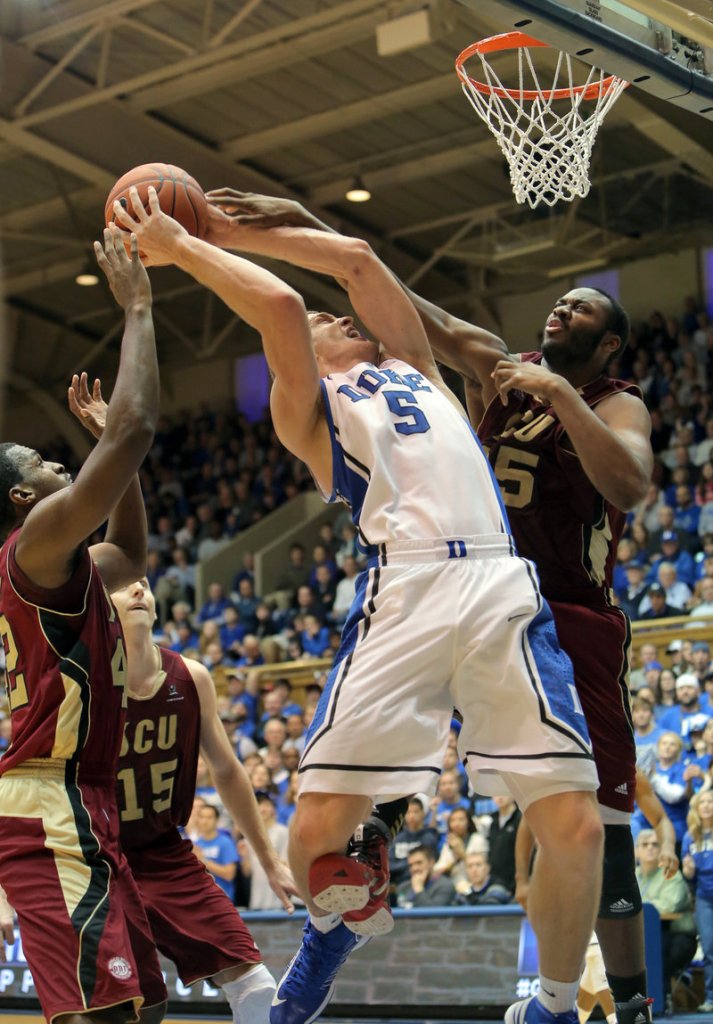 Duke’s Mason Plumlee, center, is fouled on a drive by Santa Clara’s Robert Garrett during the first half of Duke’s 90-77 win over the Broncos on Saturday at Durham, N.C.
