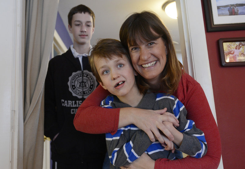 Aidan Bowie, 11, along with his mother Heather and brother Liam, 13, in the background, at their Berwick home on Monday.