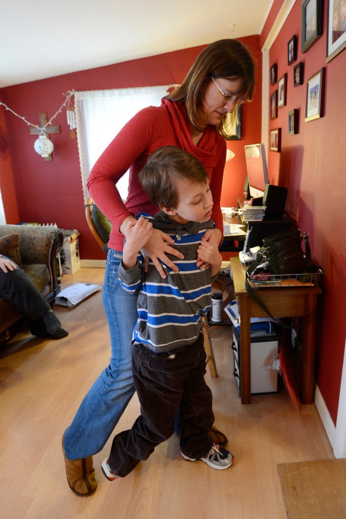 Heather Bowie helps her son Aidan, 11, walk in the family's Berwick home.