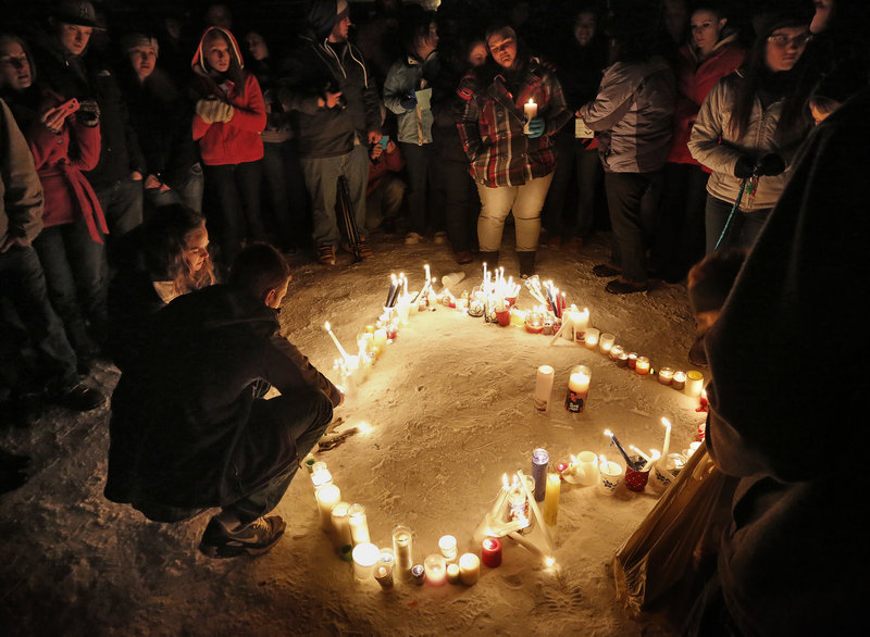 Hundreds attended a vigil at Rotary Park in Biddeford on New Year's Eve to remember Derek Thompson, 19, and his girlfriend Alivia Welch, 18, whow ere shot and killed by their landlord James Pak on Saturday. In the above photo, Friends and family form a heart with their candles.