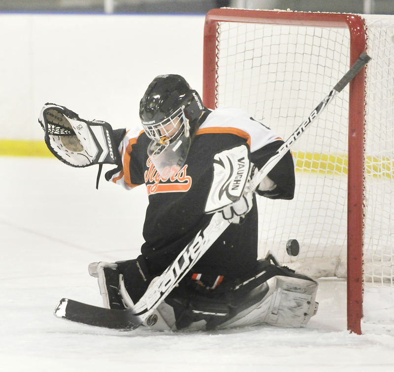 Cassie Ellis of Biddeford squeezes the goalie pads, but the puck slips through for a Cheverus goal in Wednesday’s game at the Portland Ice Arena.