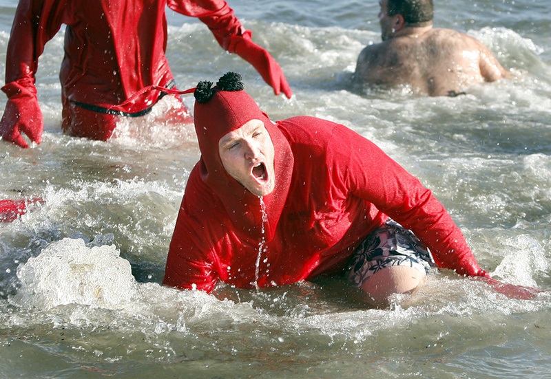 Dave Roberts of Washington, D.C., and a member of team “I Dip, You Dip, We Dip” falls into the ocean on his third dip during the 25th annual Lobster Dip to benefit Special Olympics Maine in front of The Brunswick in Old Orchard Beach on Tuesday.