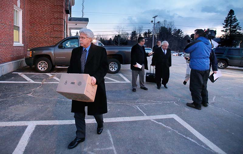 Mark Strong carries a box while leaving York County Superior Court at the end of the day on Tuesday while his attorney Daniel Lilley talks with reporters.
