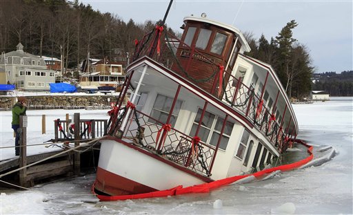 Owner of the MV Kearsarge, Peter Fenton, left, examines his sinking dinner cruise ship in Sunapee Harbor Friday, Jan. 11, 2013 in Sunapee, N.H. Authorities said the ship started to go under at about 7:45 p.m. Thursday, and part of the lower deck at the back of the boat was under water Friday morning. It was not immediately known what caused the problem. The MV Kearsarge has been taking visitors around Lake Sunapee from May through October for over 30 years. (AP Photo/Jim Cole)