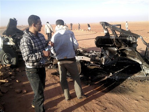In this undated photo, men look at the wreckage of a vehicle near Ain Amenas, Algeria. Algerian bomb squads scouring a gas plant where Islamist militants took dozens of foreign workers hostage found "numerous" new bodies on Sunday as they searched for explosive traps left behind by the attackers, a security official said.