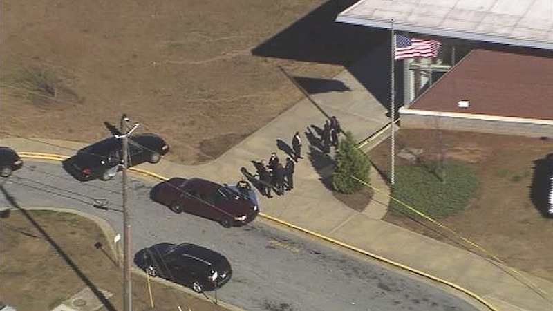 In this image made from video and released by WSB-TV, authorities investigate the scene of a school shooting, Thursday, Jan 31, 2013 in Atlanta. Authorities say a 14-year-old has been wounded in a shooting at an Atlanta middle school and a suspect has been taken into custody. Atlanta police spokesman Carlos Campos says the wounded student has been taken "alert, conscious and breathing" to Grady Hospital. (AP Photo/WSB-TV)