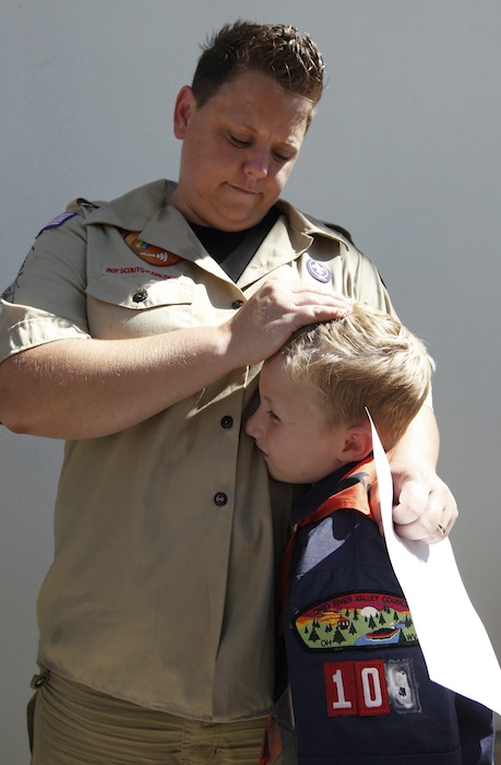 In this July 18, 2012 file photo, Jennifer Tyrrell hugs her son Cruz Burns, 7, outside Boy Scouts national offices in Irving, Texas, after a meeting with representatives of the 102-year-old organization. The Ohio woman was ousted as a den mother because she is a lesbian. The Boys Scouts of America announced Monday, Jan. 28, 2013, that it is considering a dramatic retreat from its controversial policy of excluding gays as leaders and youth members. (AP Photo/LM Otero, File)