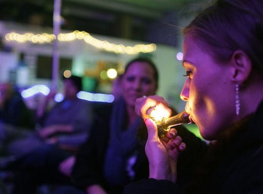 Rachel Schaefer smokes marijuana at the opening of Club 64, a marijuana social club in Denver, on Dec. 31, 2012. Maine voters approved social clubs in 2016, but lawmakers voted Wednesday to eliminate references to club licensing in their rewrite of the Marijuana Legalization Act.