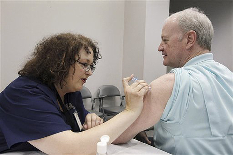 Bill Staples, a Mississippi Department of Health employee, is given a flu vaccine shot by registered nurse Rosemary Jones, also with the health department, in Jackson, Miss., last fall. A survey by Centers for Disease Control and Prevention researchers found that in 2011, more than 400 U.S. hospitals required flu vaccinations for their employees and 29 hospitals fired employees that were not vaccinated against the virus.