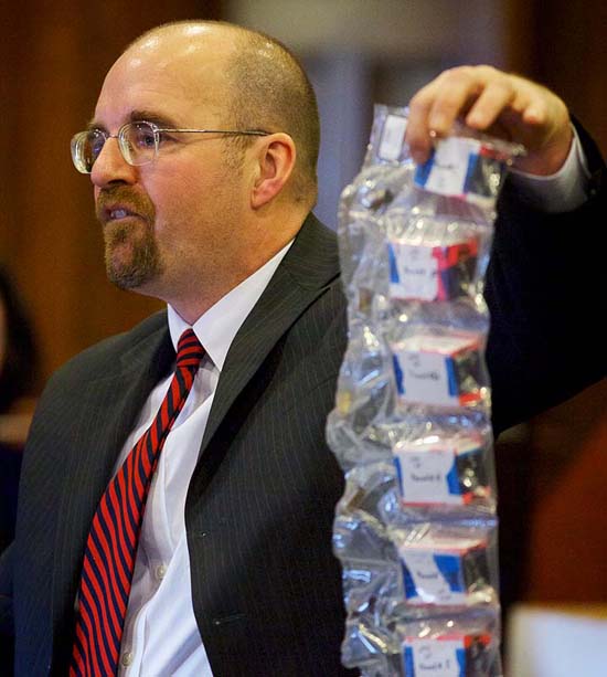 Assistant Attorney General Donald Macomber holds a bag of spent shell casings found at the scene of the crime as he presents his opening arguments in the Joel Hayden double murder trial in Cumberland County Superior Court in Portland on Monday.