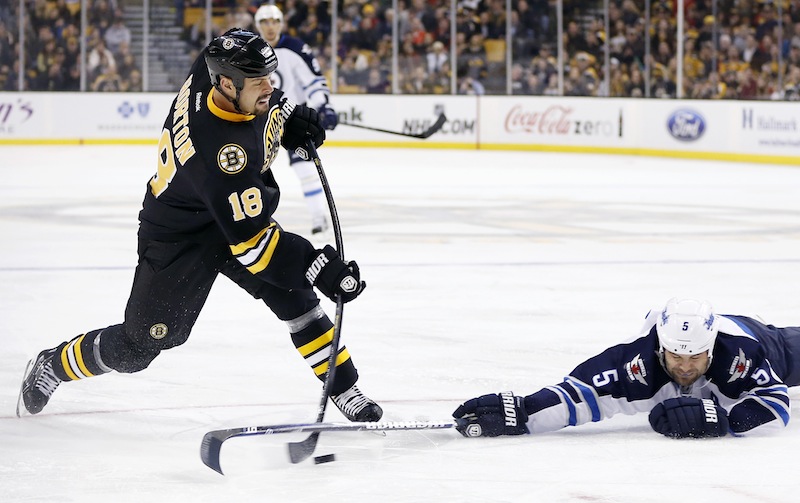 Winnipeg Jets' Mark Stuart (5) tries to block a shot on goal by Boston Bruins' Nathan Horton (18) during the second period of an NHL hockey game in Boston, Monday, Jan. 21, 2013. (AP Photo/Michael Dwyer)