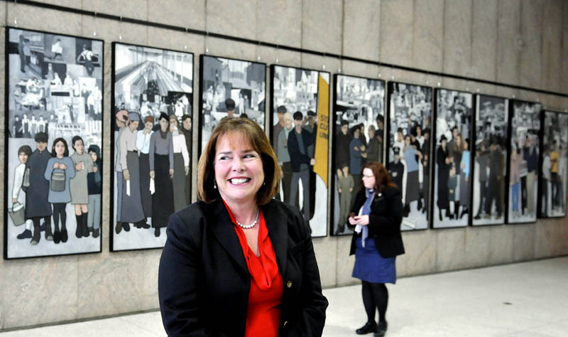 Jeanne Paquette, Maine's commissioner of labor, unveiled the labor mural on display on the wall of the Cultural Building atrium, which serves as the entryway to the Maine State Museum, in Augusta on Monday. The mural was hung over the weekend, after being removed by Gov. Paul LePage in 2011 from the Department of Labor's offices on Enterprise Drive in Augusta.
