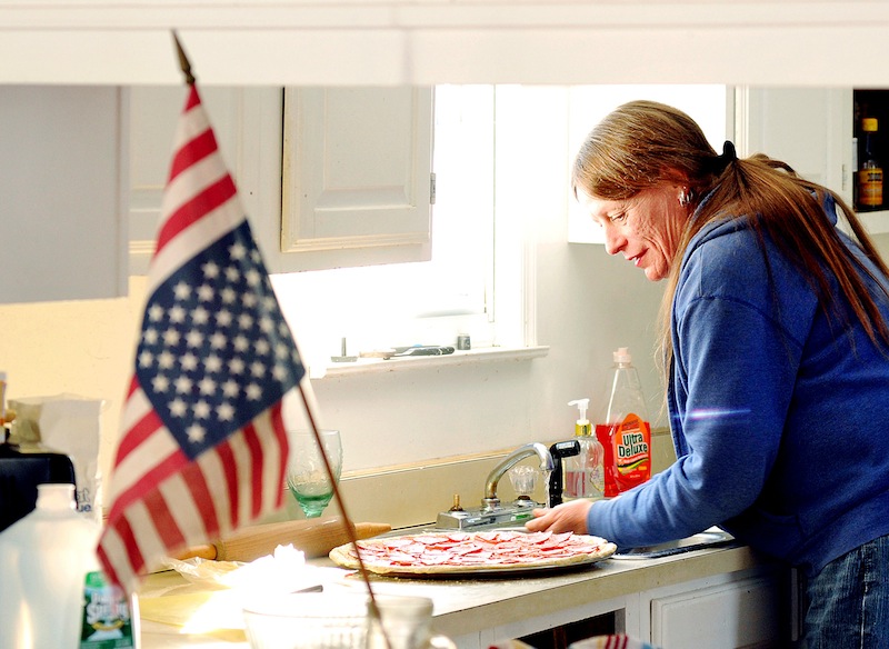 Elizabeth Tremblay makes focaccia pizza at her Poland, Maine, home on Januaray 7, 2013. "When you don't like what your government is doing, you hang your flag upside down in silent protest," said Tremblay. Tremblay was Donald Trembly when she went AWOL from the Marines 31 years ago. (AP Photo/The Lewiston Sun-Journal, Daryn Slover)