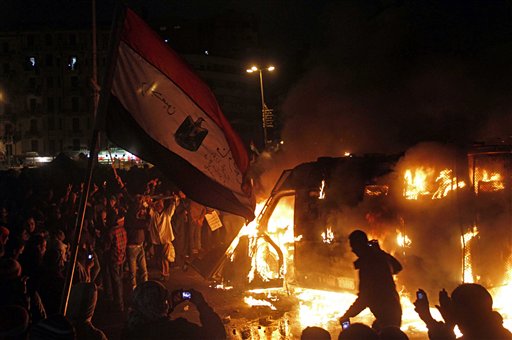 Egyptian protesters use camera phones to capture photos of a burning state security armored vehicle that demonstrators commandeered and brought to Tahrir Square and set on fire, in Cairo, on Monday.