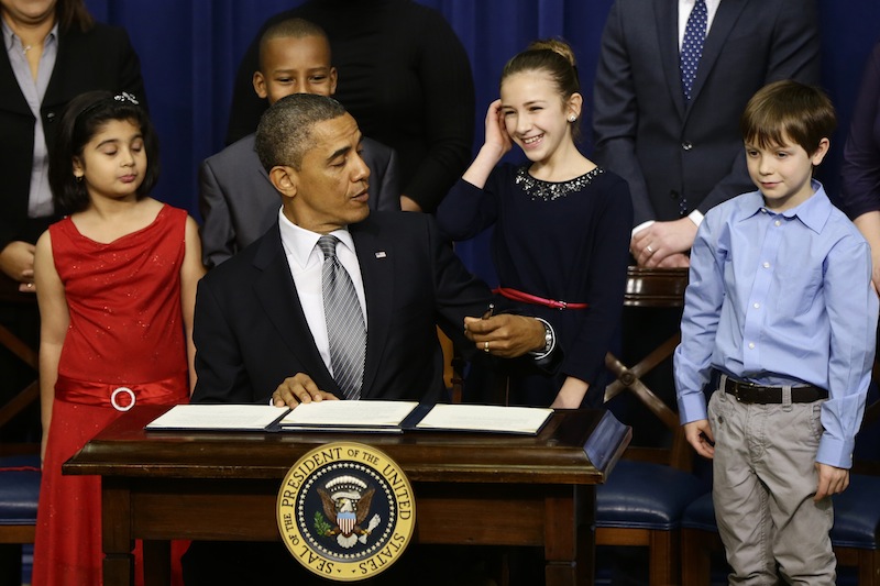 From left to right: Hinna Zeejah, 8, Taejah Goode, 10, Julia Stokes, 11, and Grant Fritz, 8, who wrote letters to President Barack Obama about the school shooting in Newtown, Conn., watch as the president jokes about being left handed as he signs executive orders outlining proposals to reduce gun violence, Wednesday, Jan. 16, 2013, in the South Court Auditorium at the White House in Washington. (AP Photo/Charles Dharapak)