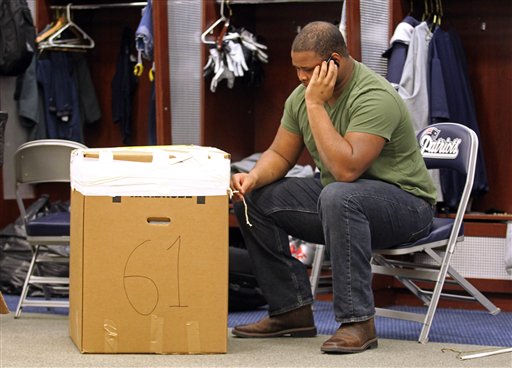 New England Patriots tackle Marcus Cannon talks on the phone next to a box of his belongings from his locker at Gillette Stadium in Foxborough, Mass., on Monday.