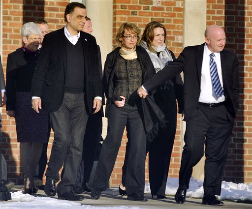 Former U.S. Rep. Gabrielle Giffords, center, holds hands with her husband, Mark Kelly, while exiting Town Hall at Fairfield Hills Campus in Newtown, Conn., after meeting with Newtown officials in this Jan. 4, 2013, photo.