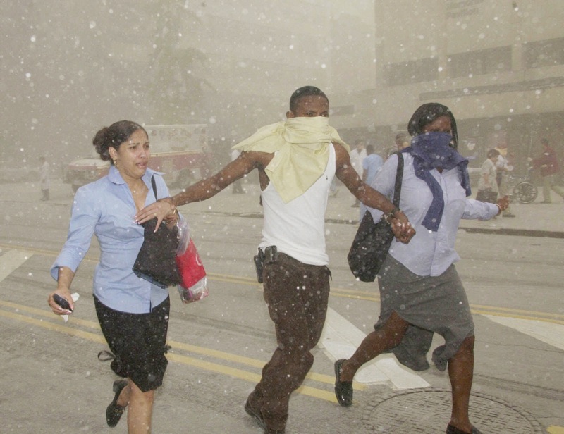 In this Sept. 11, 2001 file photo, three people may their way through a cloud of caustic dust after terrorists flew two airliners into the World Trade Center towers, bringing them down. The special fund set up by Congress to compensate people who fell ill after being exposed to ash and dust from the World Trade Center is making its first round of payments, more than two years after the money was appropriated. (AP Photo/Suzanne Plunkett, File)