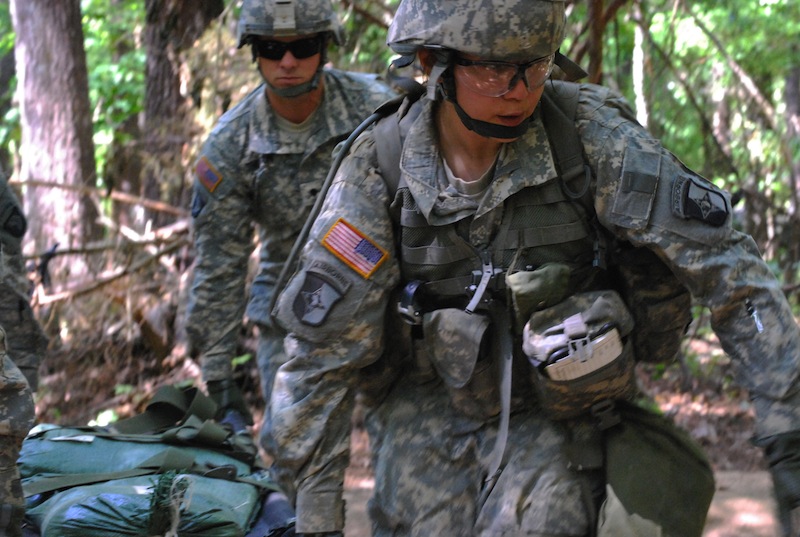 In a May 9, 2012 file photo, Capt. Sara Rodriguez, 26, of the 101st Airborne Division, carries a litter of sandbags during the Expert Field Medical Badge training at Fort Campbell, Ky. The Pentagon is lifting its ban on women serving in combat, opening hundreds of thousands of front-line positions and potentially elite commando jobs after generations of limits on their service, defense officials said Wednesday, Jan. 23, 2013. (AP Photo/Kristin M. Hall, File)