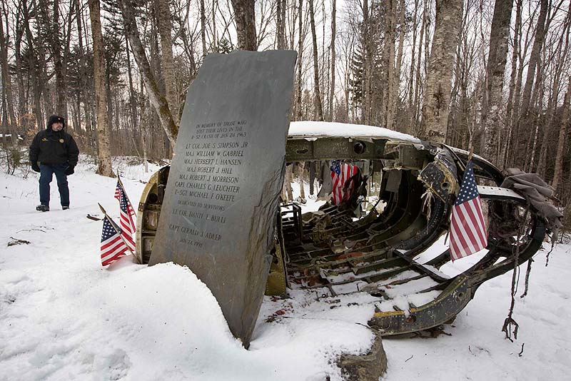 In this photo on Dec. 14, 2012, Greenville Police Chief Jeff Pomerleau views a monument next to wreckage from a B-52 bomber on Elephant Mountain near Greenville. The plane's 40-foot-tall vertical stabilizer had snapped off and crashed on Jan. 24, 1963. Seven of the nine people on board died in the crash.
