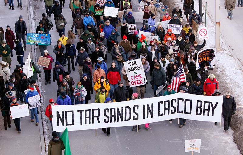 People march down Commercial Street in Portland on Saturday to protest what they say is an emerging proposal to send tar sands oil from Canada through a pipeline to Portland harbor. Officials with the Portland Pipeline Corp., which owns the pipeline, says there is no existing proposal to send tar sands oil through the pipeline.