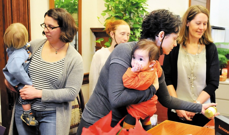 Lilijana Cvetkoska of Cape Elizabeth holds her infant daughter while leaving baby food on the desk of Gov. Paul LePage's receptionist on Jan. 9, as she and others show their support for a ban on BPA in baby food containers.