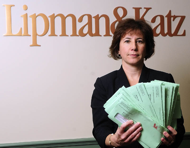 Attorney Karen Boston displays about 60 letters received at the Lipman & Katz law firm on Wednesday in Augusta. The letters asked for corporate directors' names, addresses and $125 from "Corporate Records Services."