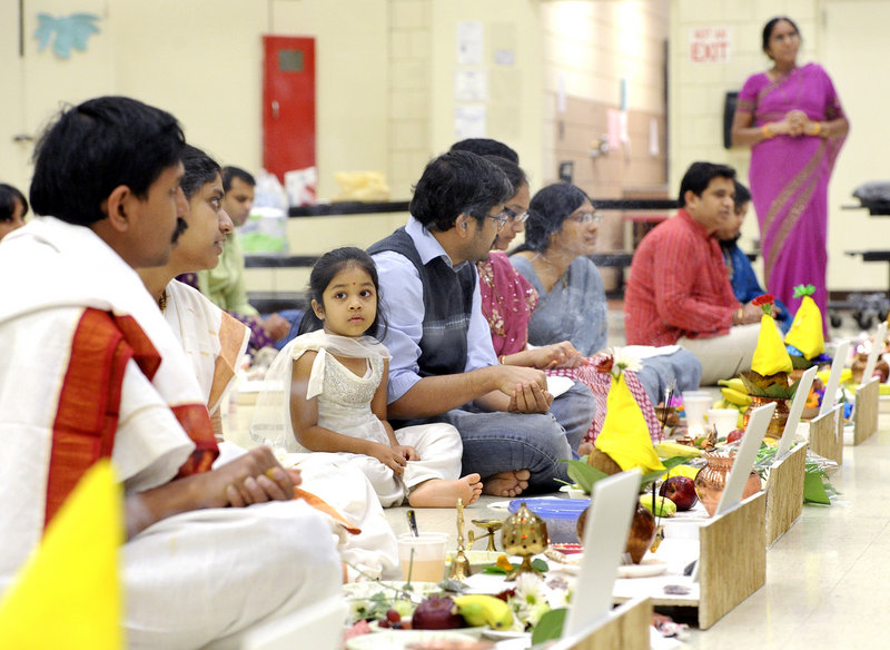 Three-year-old Srehitta Patnayakuni watches with her parents at the Dec. 1 prayer service held by the Maine Hindu Temple. The group's offer on a Westbrook church was later accepted and fundraising was successful.